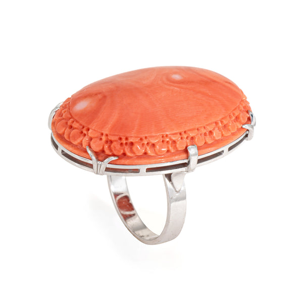 Carved coral ring with white gold band on a white background
