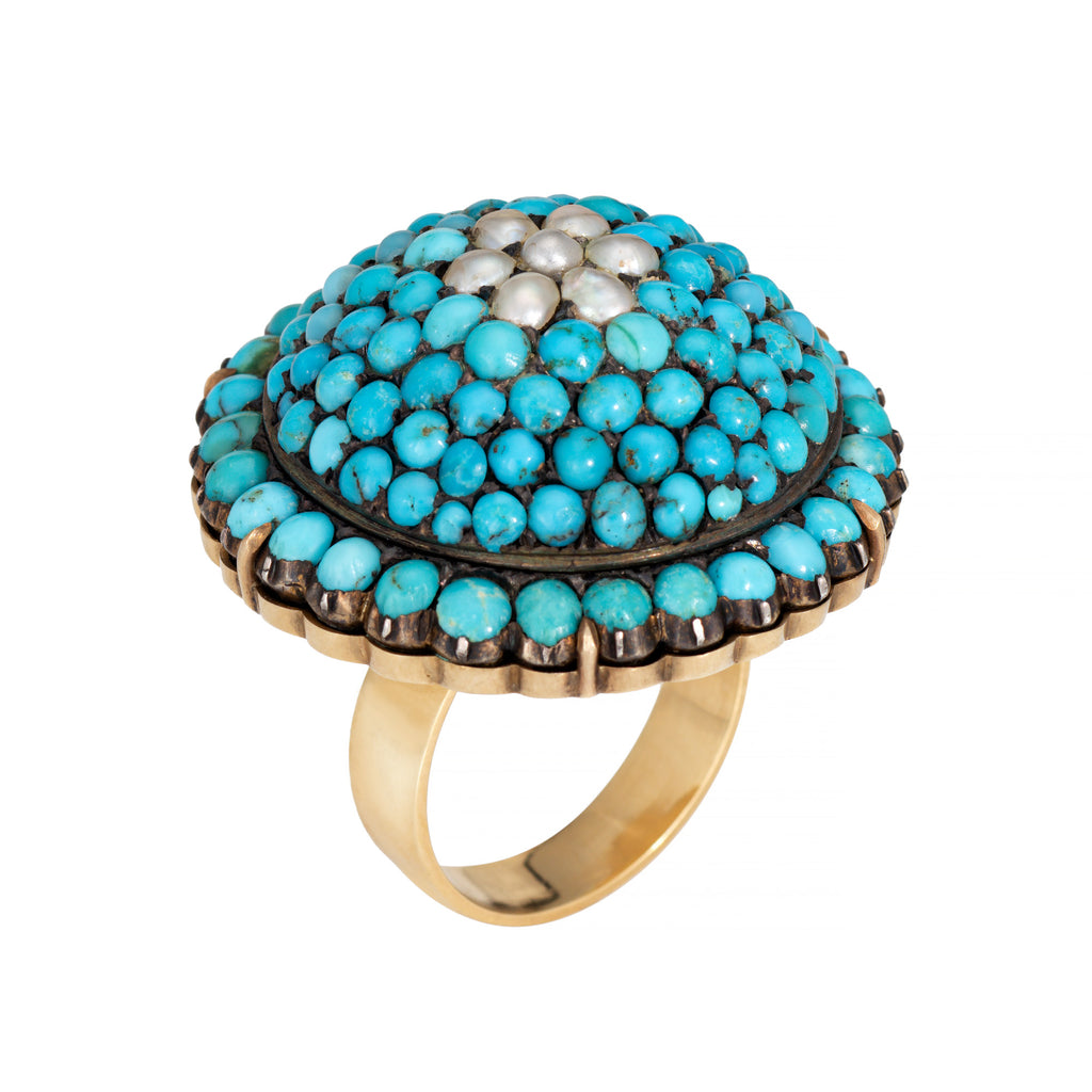 Ring with turquoise stones and pearl-like centers on a white background