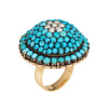 Ring with turquoise stones and pearl-like centers on a white background