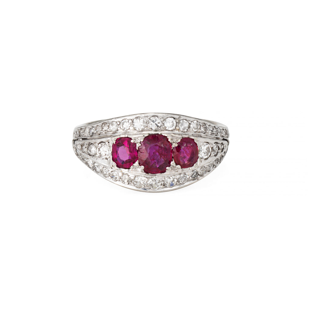 Vintage Art Deco three ruby gemstones and diamond-studded band on a white background