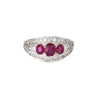 Vintage Art Deco three ruby gemstones and diamond-studded band on a white background