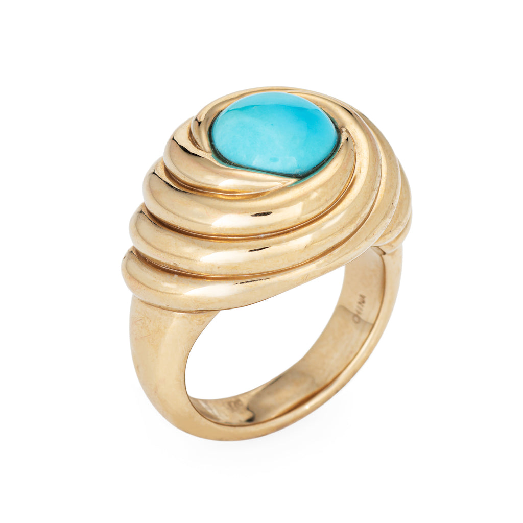 Gold ring with a turquoise stone on a white background