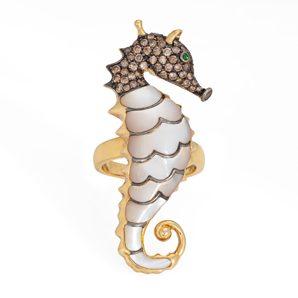 Seahorse-shaped jewelry with gemstones on a white background