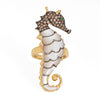 Seahorse-shaped jewelry with gemstones on a white background